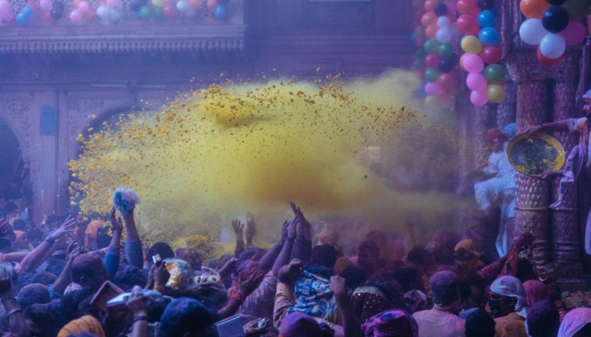 Festeggiamenti durane l'Holi Festival in India, con polvere colorata gialla lanciata in aria sulle persone