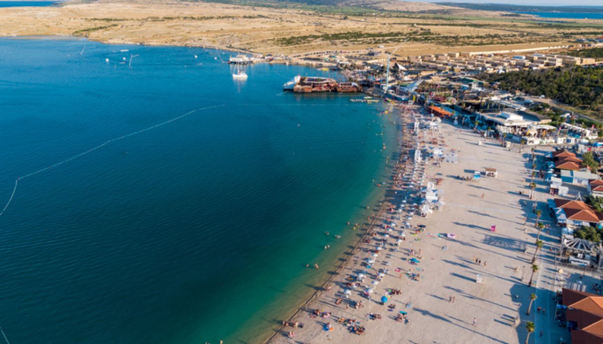 Veduta aerea della spiaggia di Zrcé, a Novaljia in Croazia, con bagnanti e locali notturni sullo sfondo